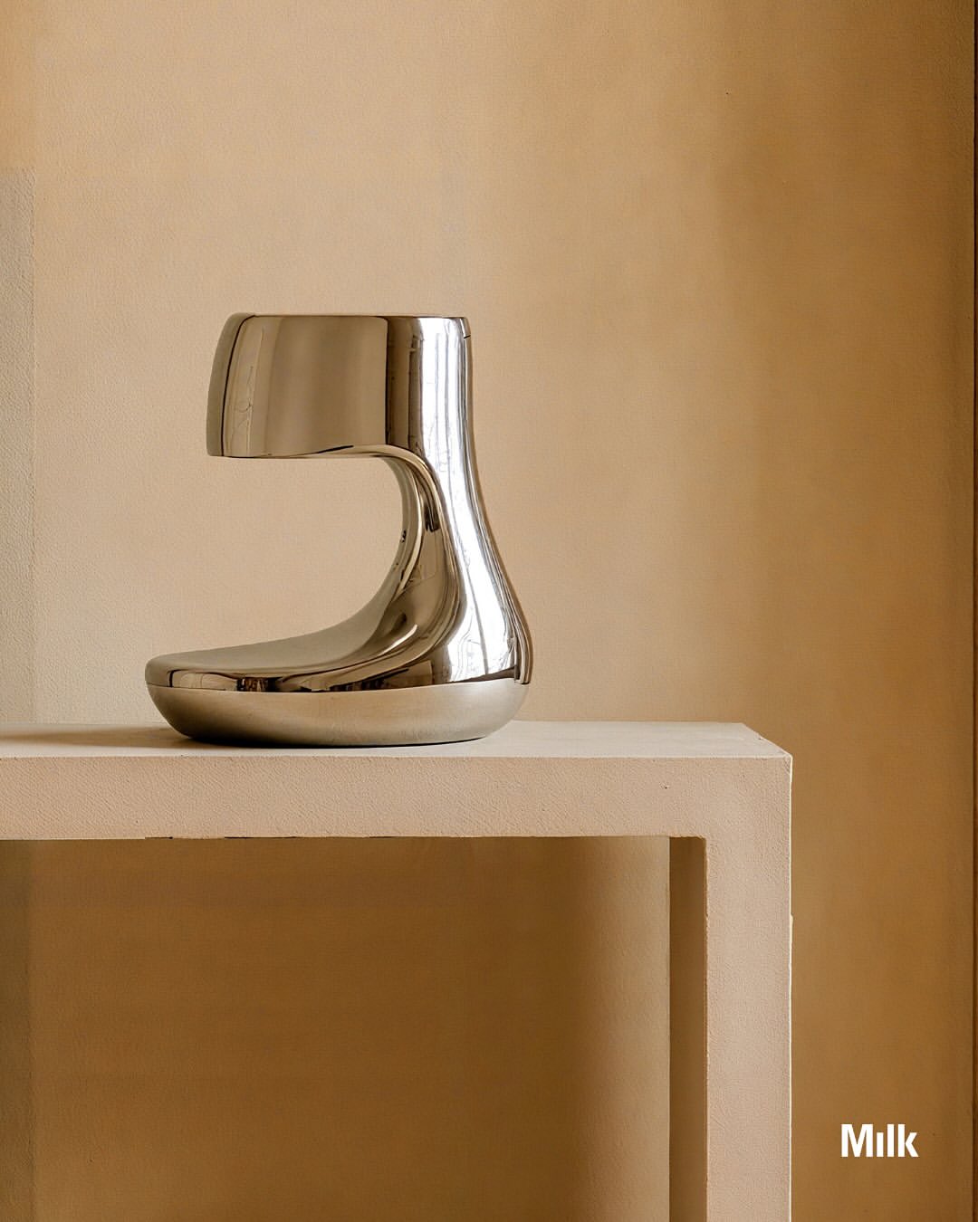 Artist Spotlight: @paddypikestudio ‘s Arnardo Collection emerges from lumps of virtual clay, distorted and molded into creature like silhouettes that foreground how emergent technologies are reshaping the sculptural language of contemporary furniture. Named after an anagram of Ron Arad, the series echoes Arad’s playful manipulation of industrial steel while bringing its explorations into the meta realm.

Beginning in VR, Pike maneuvers around the forms as if they were physical, then creating visualizations through 3D rendering, AI image generation, and Photoshop. The resulting digital studies become the blueprint for fabricating polished stainless steel.

“The lamp with its twin giraffe-like necks, the desk standing solid on elephantine bases, the cabinet short and round like a resting hippo – The Arnardo Collection has given me the confidence to work with stainless steel in a way that challenges both myself and the material. I enjoy being pushed out of my comfort zone, but I also like to push the material beyond its own conventions, asking it to be fluid, playful, and alive.”