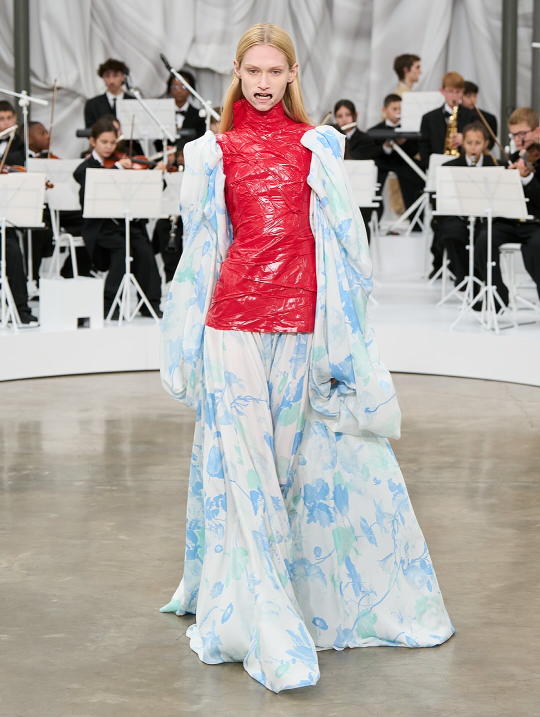 Maison Margiela Co-Ed SS26, Paris Fashion Week

At the recent Paris Fashion Week, Glenn Martens revealed his first ready-to-wear collection for Maison Margiela, following his debut at the Haute Couture show last July.
The collection immediately made an impression, notably with the four metal bars that stretched the models’ mouths, reminiscent of dental retractors, yet shaped in the brand’s iconic Four Stitches motif.
Tailoring was reinvented this season with innovative shoulder constructions, ultra-low-rise trousers, and jackets with tie closures. The runway also showcased striking textures: 16th-century floral wallpaper prints recreated on knitwear, tops made from fused and recycled vintage jewelry, silk jackets and coats fully coated in plastic for a waterproof effect, knitted plastic fabrics, and corsets and shoulder details on certain dresses.
For his debut show, Glenn Martens offered “fresh design ideas alongside reimagined and evolved pieces from the archives, crafted by the entire Maison Margiela team.”

Creative Direction @maisonmargiela @glennmartens
Styling @ursinagysi
Make Up @ingegrognard
Hair @garygillhair
Nails @cam.t.artist
Backstage Photographer @melanie_ramon 
Post House @sheriff.projects
#sheriffprojects