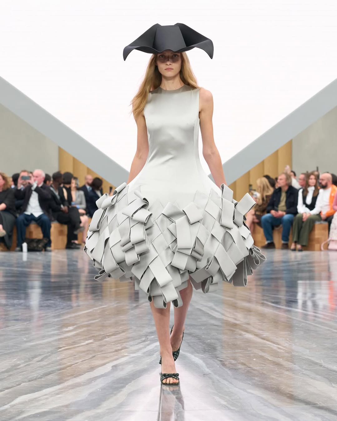 Dior SS26, Paris Fashion Week

During the latest Paris Fashion Week, Jonathan Anderson unveiled his first womenswear collection for Dior. The show opened with an Adam Curtis–directed short film projected on a pyramidal screen, tracing Dior’s creative legacy, from Christian Dior’s floral silhouettes to Galliano’s theatrical flair, while paying homage to Maria Grazia Chiuri’s artistic influence.
Models appeared from behind an open Dior archival box, wearing reimagined classics infused with Anderson’s postmodern, surreal touch. The opening look, a white dress echoing Dior’s 1952 “Cigale” design, set the tone with exaggerated bows and sculptural shapes. Throughout, Anderson intertwined his own aesthetic with the house’s heritage, blending historical drama with contemporary edge: peplum blazers paired with frayed denim, transparent gowns over nude bodysuits, and voluminous caban coats. Stephen Jones’s origami hats and rose-toe shoes completed a collection that elegantly bridged Dior’s past and Anderson’s avant-garde vision.

Creative Direction @dior @jonathan.anderson
Styling @benjaminbruno_
Make Up @peterphilipsmakeup
Hair @guidopalau
Backstage Photographer @mireia_deulofeu
Post House @sheriff.projects
#sheriffprojects